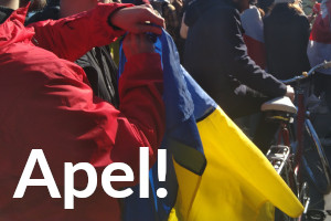 Ręce rozwijają flagę ukraińską. W tle więcej osób i rower. Na dole napois: "Apel!"